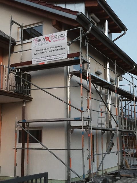 Gerüst an einer Fassade mit dem Bauschild von Bisch & Baykal